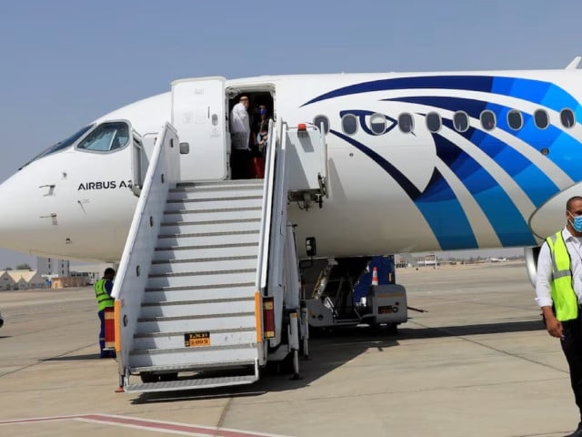 an employee of luxor s international airport walks next to an egyptair plane in luxor egypt april 9 2021 photo reuters